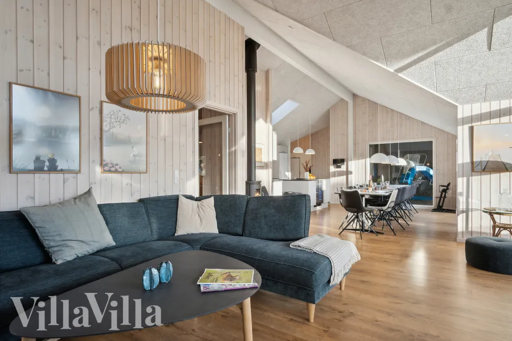 Stue med brændeovn og spisebord i sommerhus på Rømø